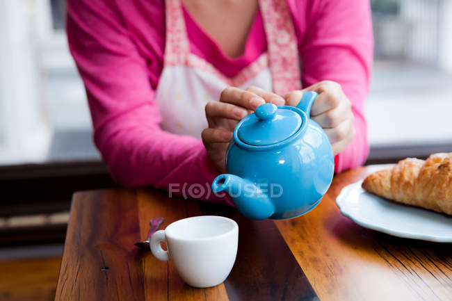 Primer plano de la mujer Verter té en la taza - foto de stock