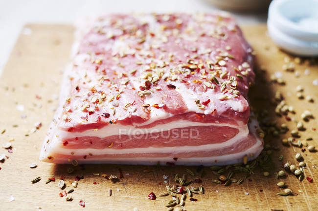 Vientre de cerdo crudo con semillas de cilantro e hinojo - foto de stock