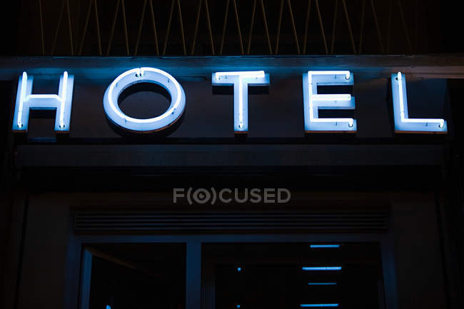 Letrero de neón iluminado para un edificio de hotel - foto de stock