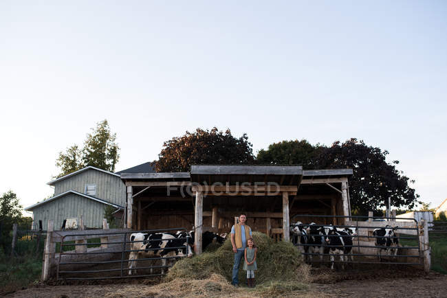 Портрет батька і дочки біля коров'ячого сараю — стокове фото
