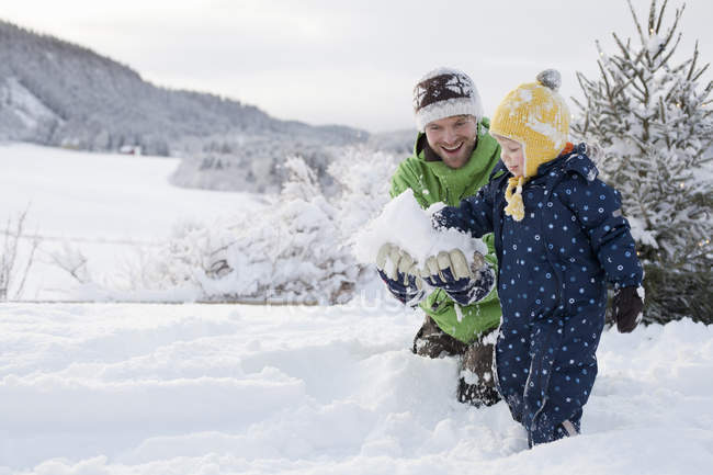 Padre e figlio che giocano nella neve in campagna paesaggio — Foto stock
