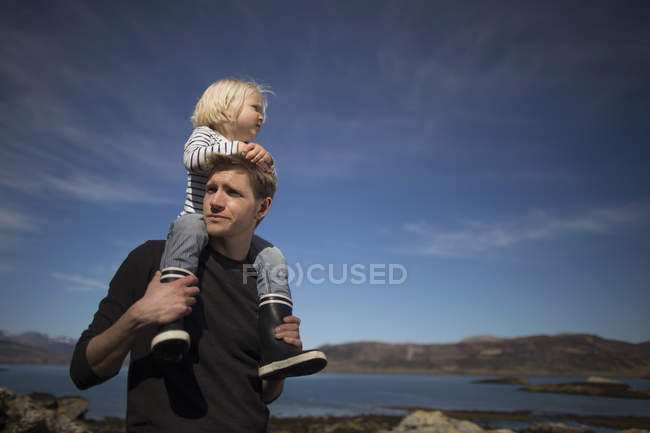 Father carrying son on shoulders, Loch Eishort, Isle of Skye, Hebrides, Scotland — Stock Photo