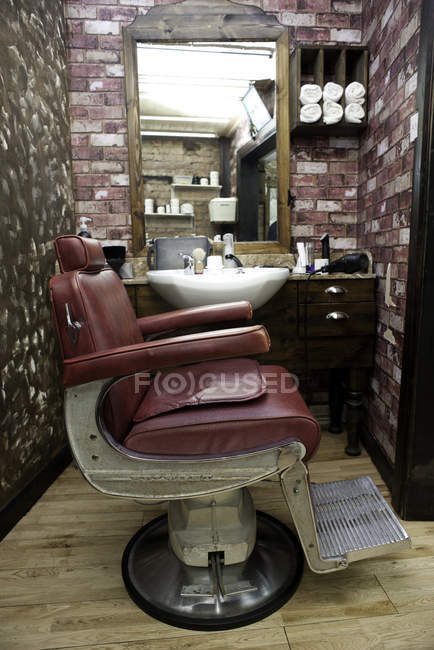 Seitenansicht eines Stuhls aus Burgunderleder im Friseurladen — Stockfoto