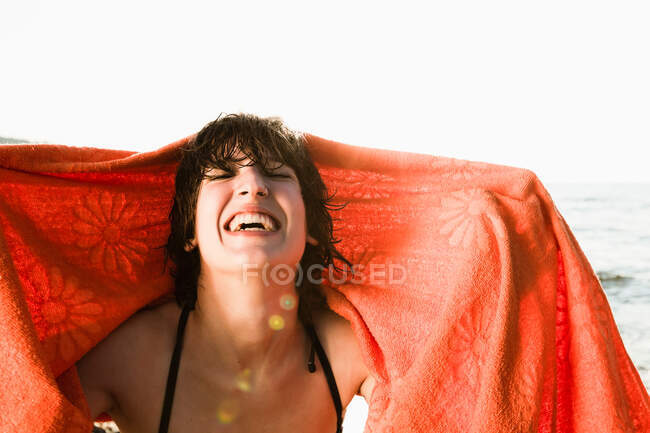 Улыбающаяся женщина играет с полотенцем — стоковое фото