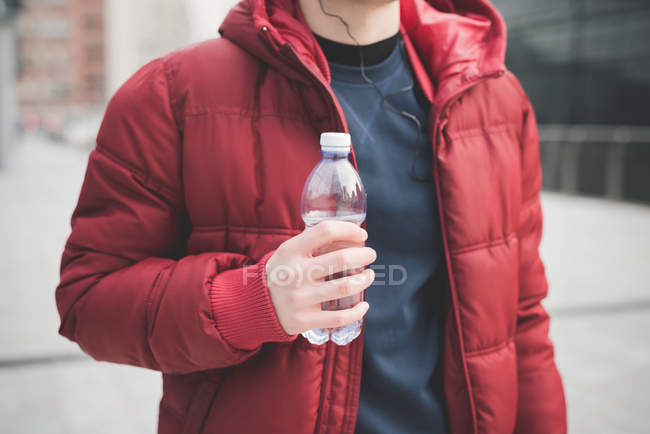 Cropped shot of young man drinking water outside city office — Stock Photo