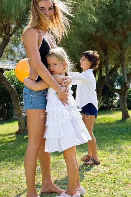 Woman and kid hugging each other on lawn — Stock Photo