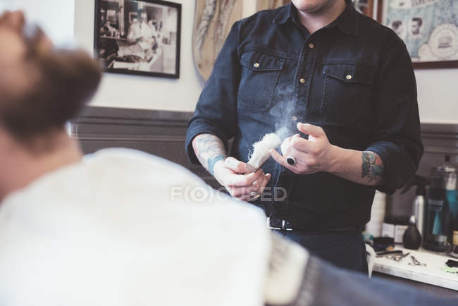 Barbeiro preparando escova de barbear na barbearia — Fotografia de Stock