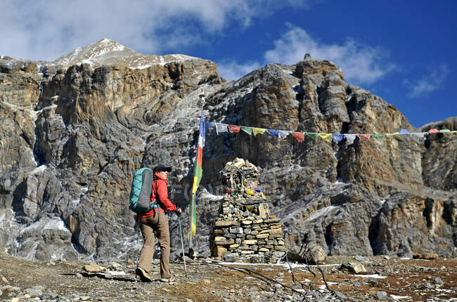 Trekker femminile vicino alle bandiere di preghiera, Thorung La, Nepal — Foto stock