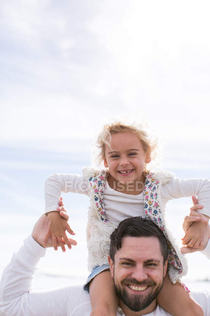 Porträt eines reifen Mannes, der seiner Tochter an der Küste einen Schulterkoffer schenkt — Stockfoto