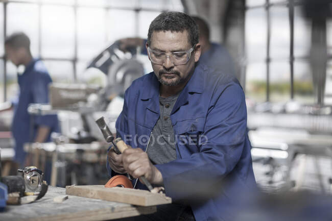 Cape Town, South Africa, machinist in workshop cutting out wood with wood cutting tools — Stock Photo