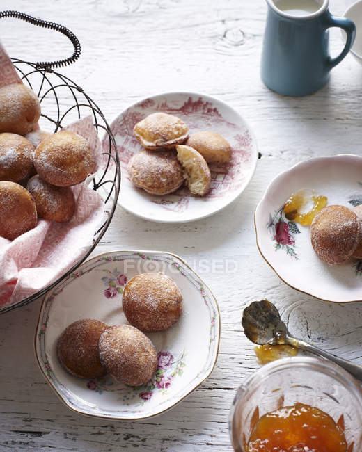 Top view of aebleskive on tea plates and bowl of jam — Stock Photo