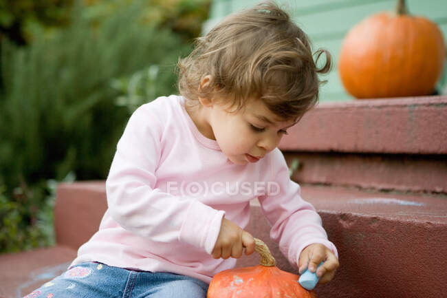 Toddler girl looking in pumpkin — Stock Photo