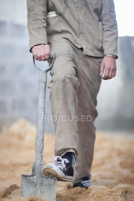 Обрізане зображення людини, що стоїть з лопатою — стокове фото