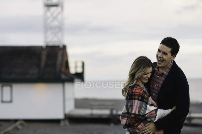 Молодая пара на улице, обнимающая, смеющаяся — стоковое фото
