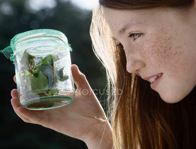 Chica sosteniendo tarro de insectos - foto de stock