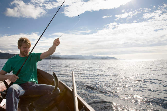 Man fishing on wooden boat — Stock Photo