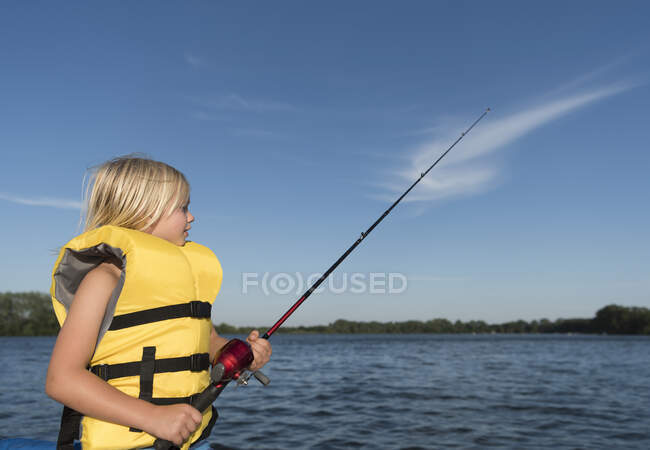 Menino vestindo vida jaqueta de pesca — Fotografia de Stock