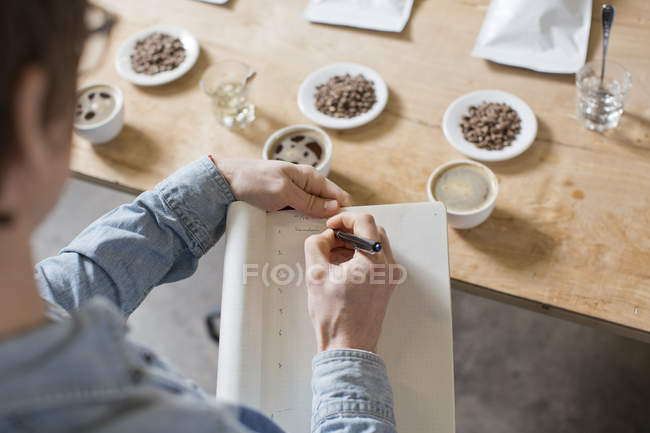 Coffee taster writing notes — Stock Photo