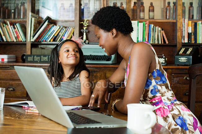 Mother and daughter using laptop at home — Stock Photo
