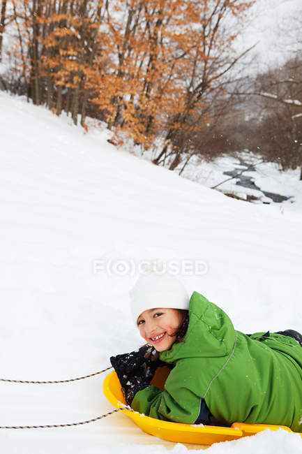 Fille traîneau dans la neige — Photo de stock