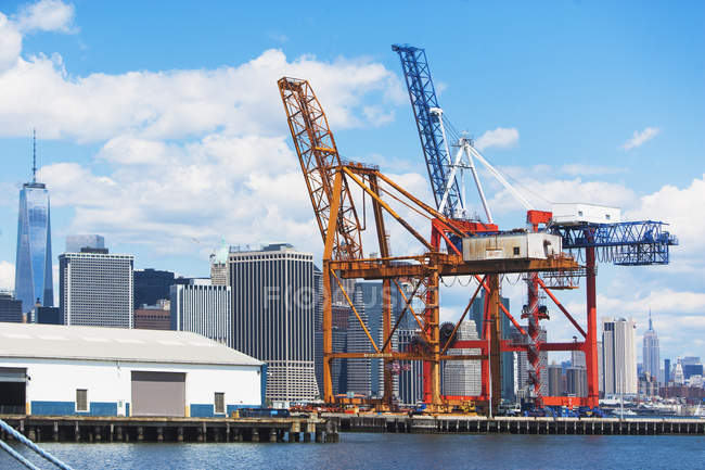 Dois guindastes de carga no porto e horizonte de Nova York, Nova York, EUA — Fotografia de Stock