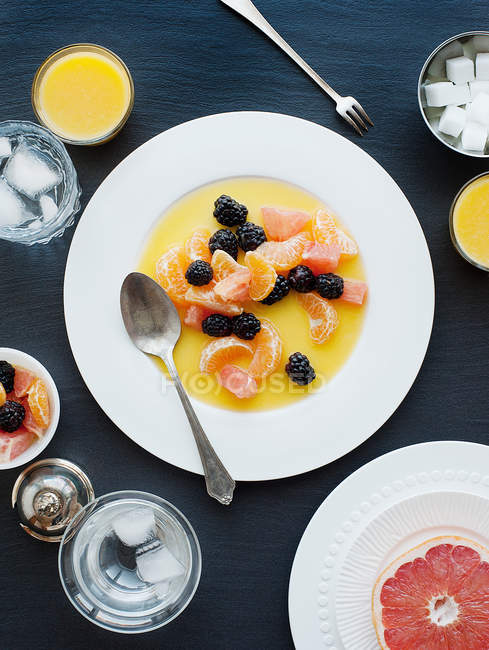Teller mit Früchten und Orangensaft — Stockfoto