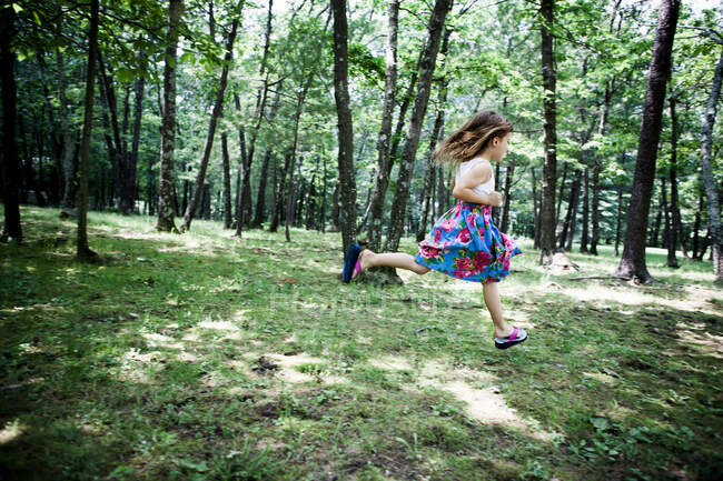 Fille courir dans la forêt — Photo de stock