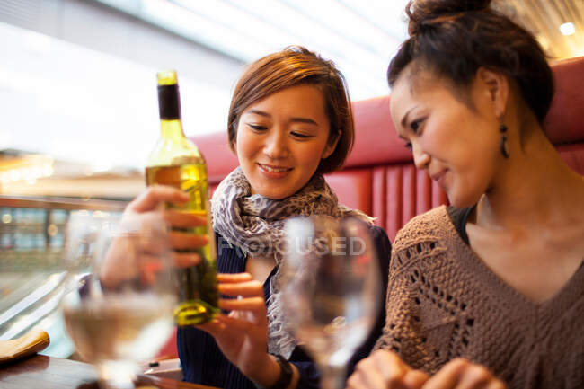 Молодые женщины с бутылкой вина — стоковое фото