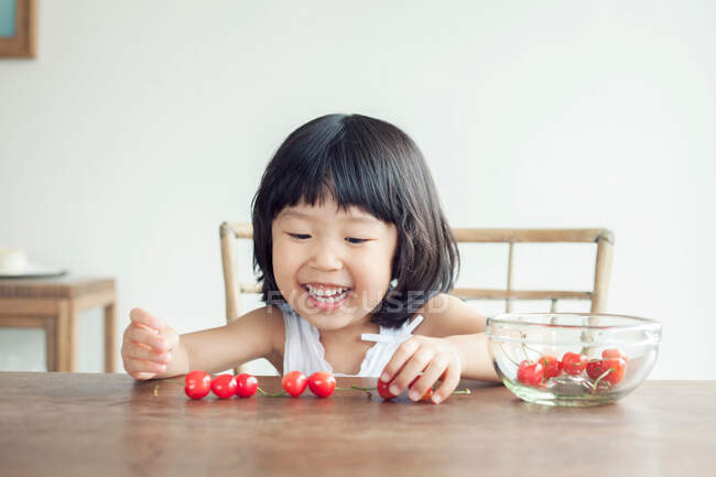Girl with bowl of cherries — Stock Photo