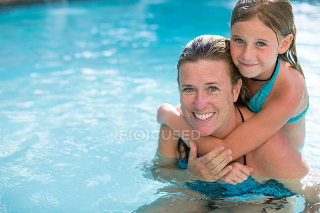 Retrato de menina e mãe na piscina exterior — Fotografia de Stock