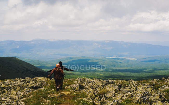 Rear view of man and woman hiking in rugged landscape, Ural Mountains, Russia — Stock Photo