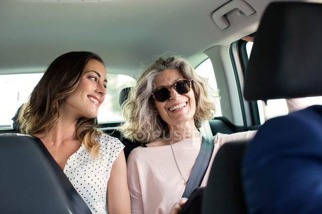 Two women chatting in back seat of car — Stock Photo