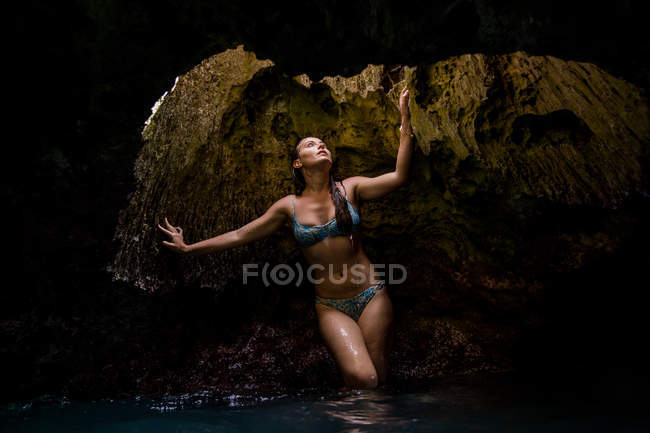 Женщина в заполненной водой пещере и глядя вверх, Оаху, Гавайи, США — стоковое фото