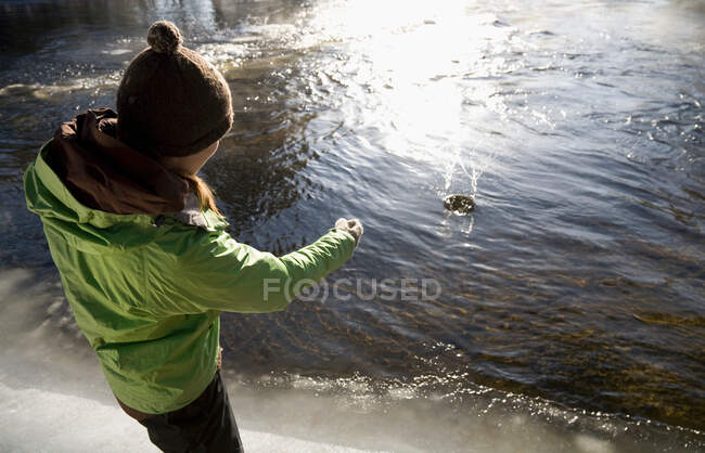Mujer robando piedras en el lago - foto de stock