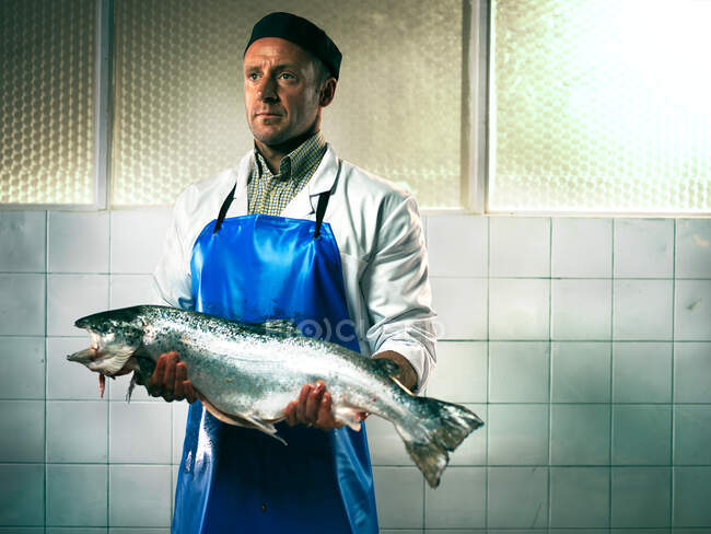 Pescadero sosteniendo un salmón - foto de stock
