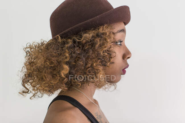 Studio portrait of woman in profile wearing hat — Stock Photo