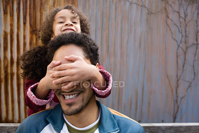 Daughter covering fathers eyes — Stock Photo