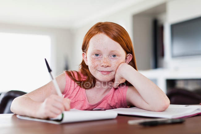 Sorrindo menina fazendo lição de casa — Fotografia de Stock