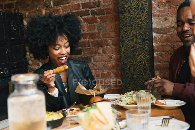 Друзі діляться їжею разом у кафе — стокове фото