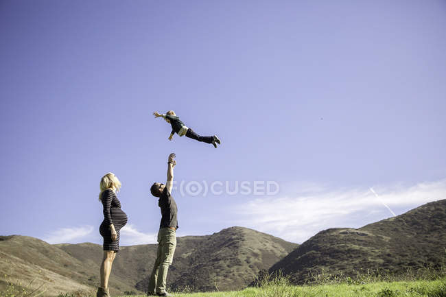 Padres y niños disfrutando del día al aire libre - foto de stock