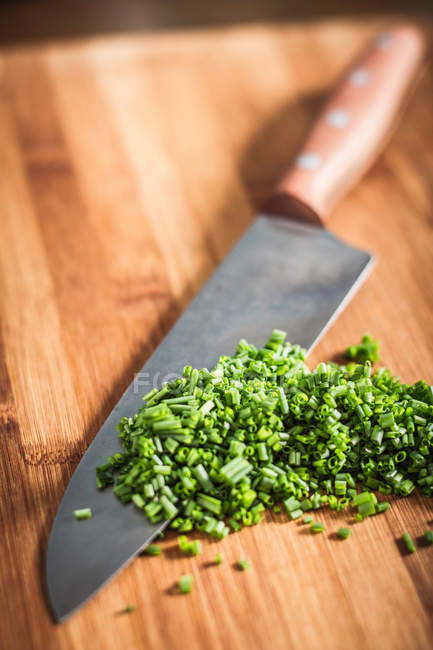 Close up shot of knife and chopped chives — Stock Photo