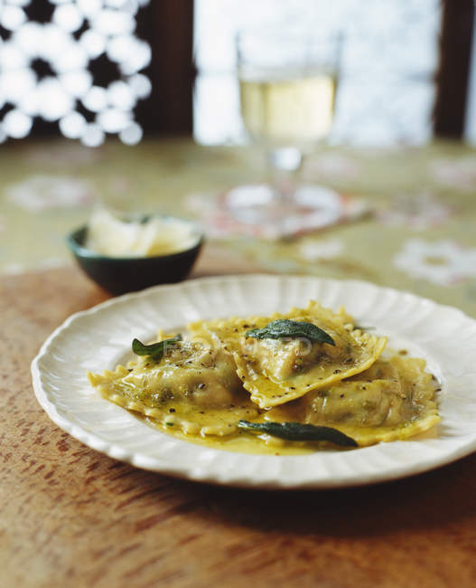 Plato de ravioles con mantequilla, pimienta, hierbas y parmesano - foto de stock