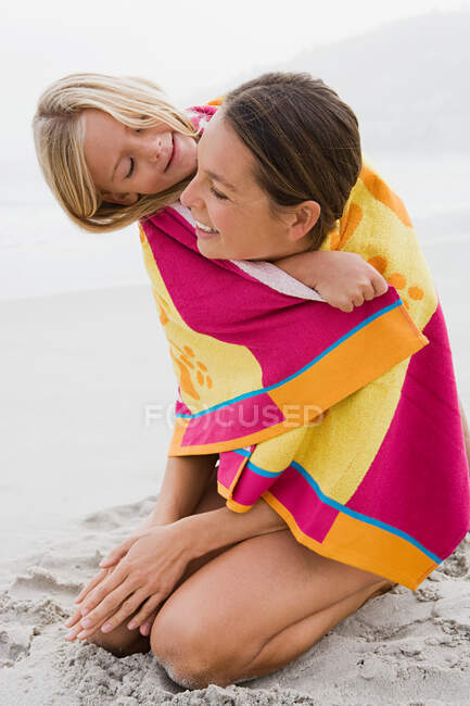 Madre e hija en una toalla - foto de stock