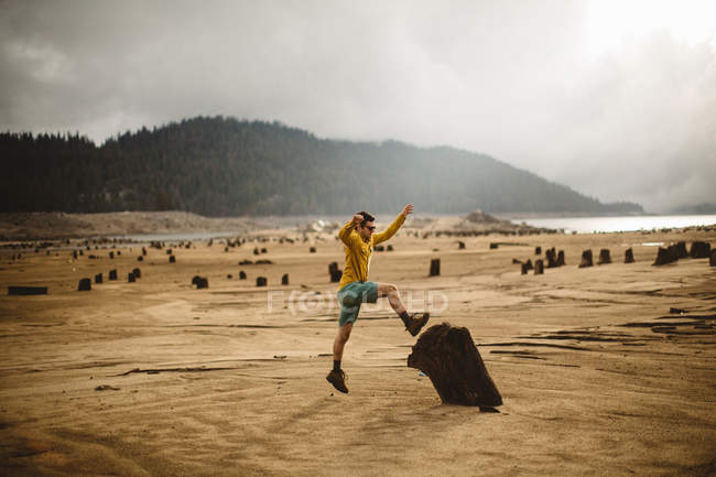 Junger Mann springt auf Holz, Huntington Lake, Kalifornien, USA — Stockfoto