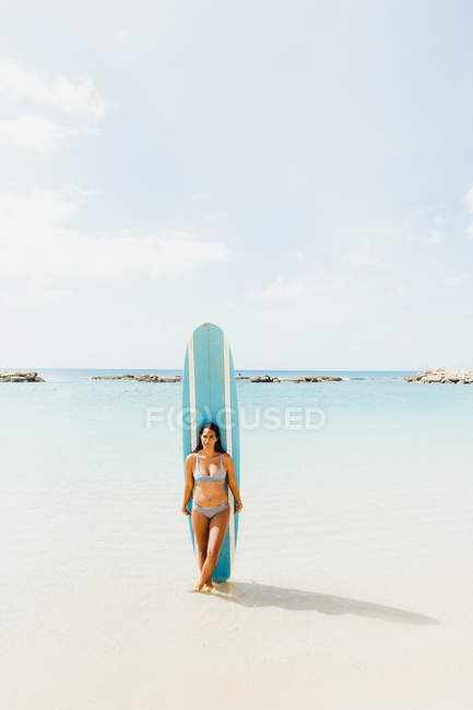 Donna in spiaggia con tavola da surf, Oahu, Hawaii, Stati Uniti d'America — Foto stock