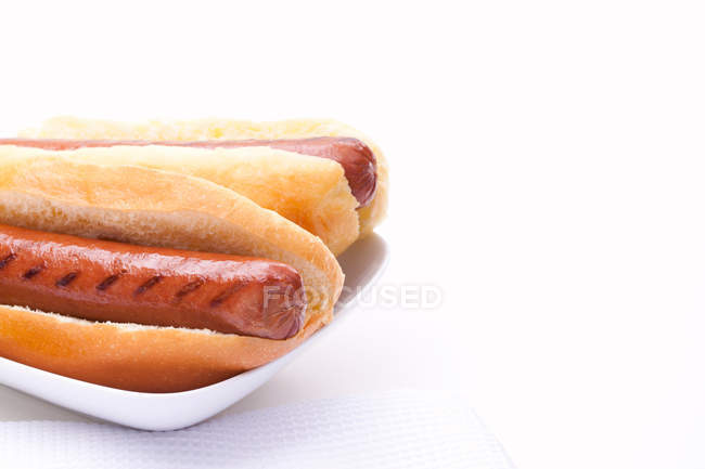 Due hot dog con salsicce alla griglia sul piatto — Foto stock