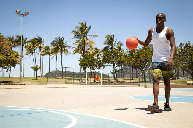 Junger Mann übt Basketball auf Basketballplatz — Stockfoto