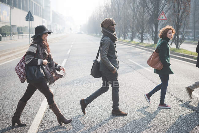 Чотири молоді дорослі перетинають міську дорогу — стокове фото