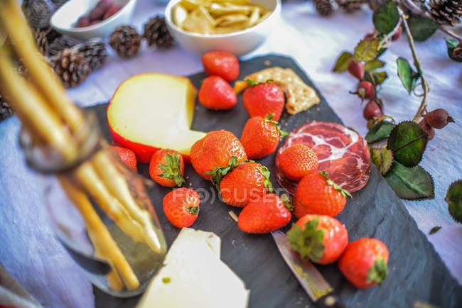 Morangos maduros e queijo na mesa de piquenique — Fotografia de Stock