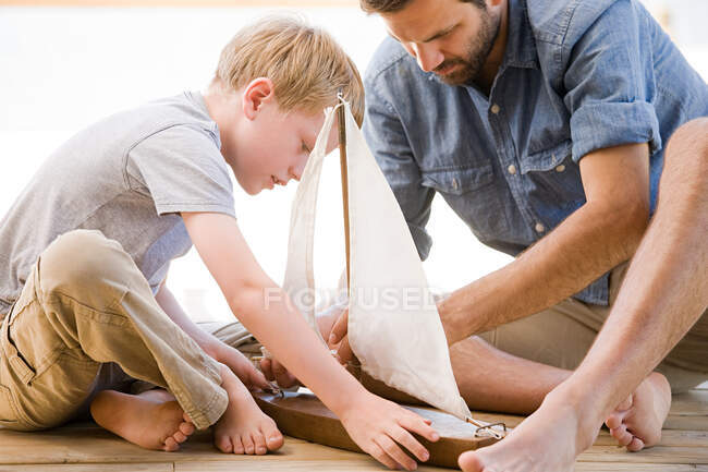 Father and son with toy boat — Stock Photo
